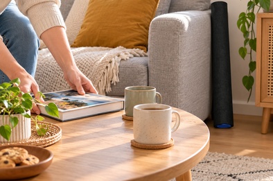 Tapis à puzzle enroulé posé discrètement contre un canapé, la table du salon redevenue libre
